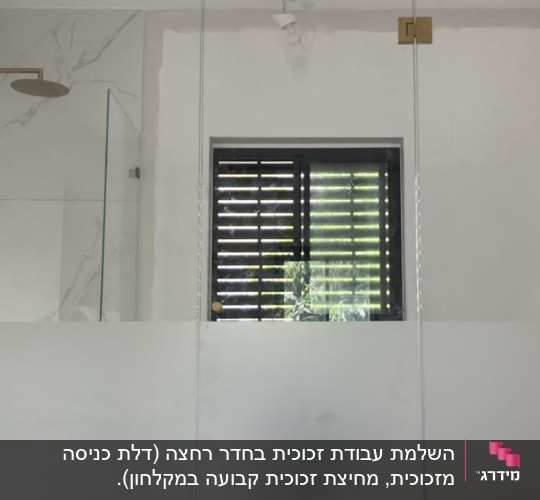 דלת זכוכית עם צירים מוזהבים בחדר רחצה
